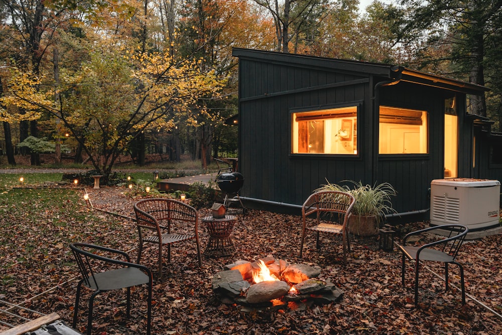 a small cabin in the woods with a fire pit