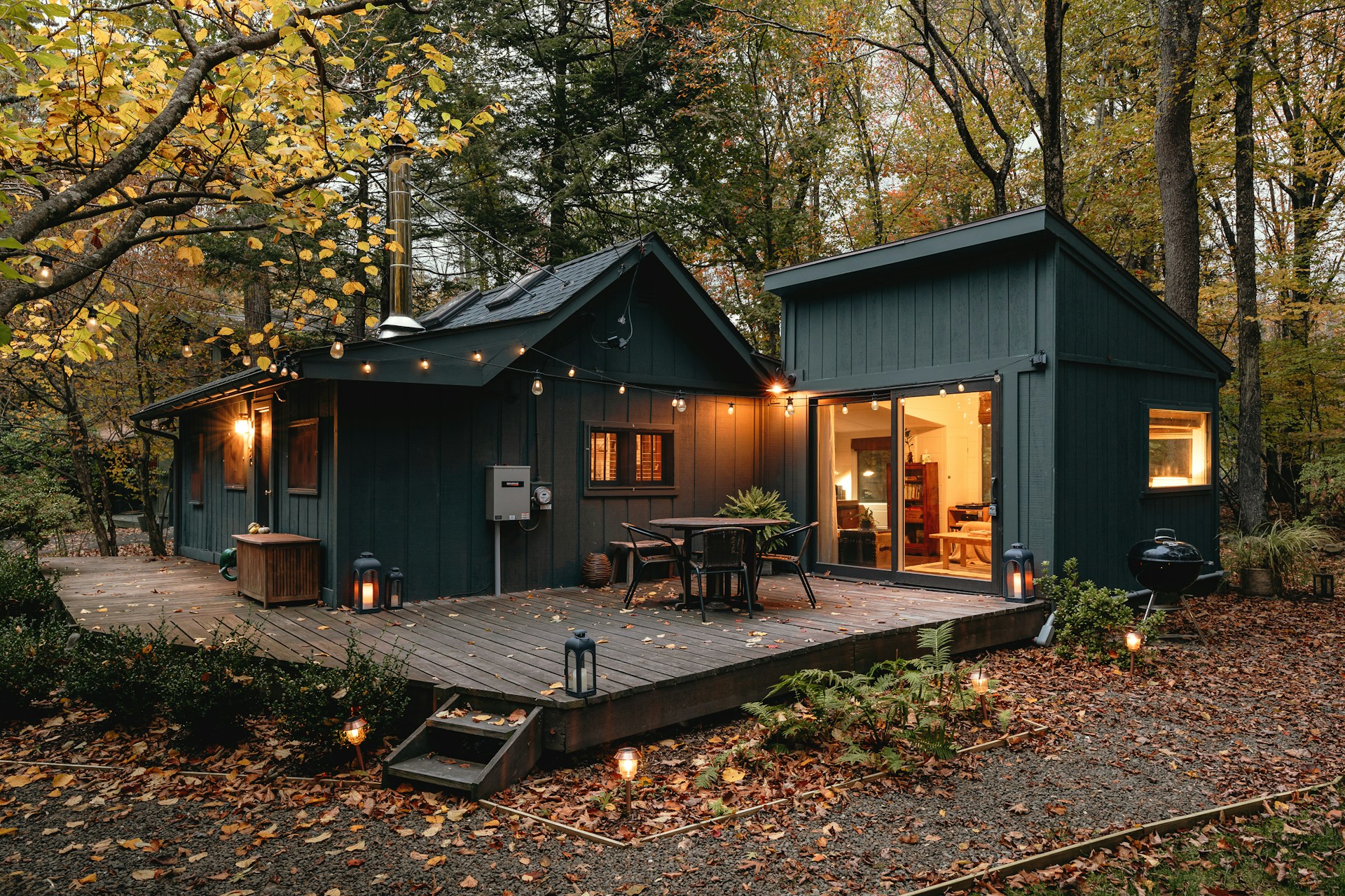 a small cabin with a deck in the woods