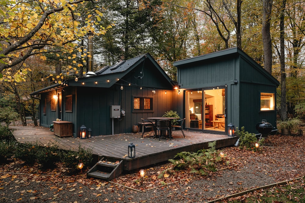 eine kleine Hütte mit einer Terrasse im Wald