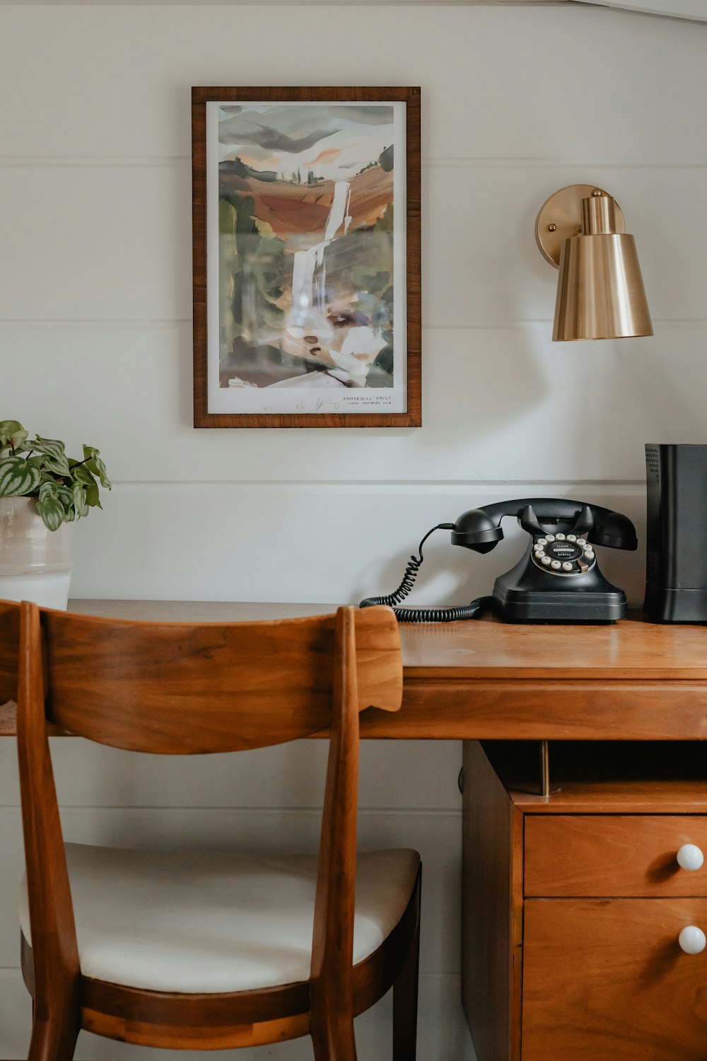 a wooden desk with a phone on top of it