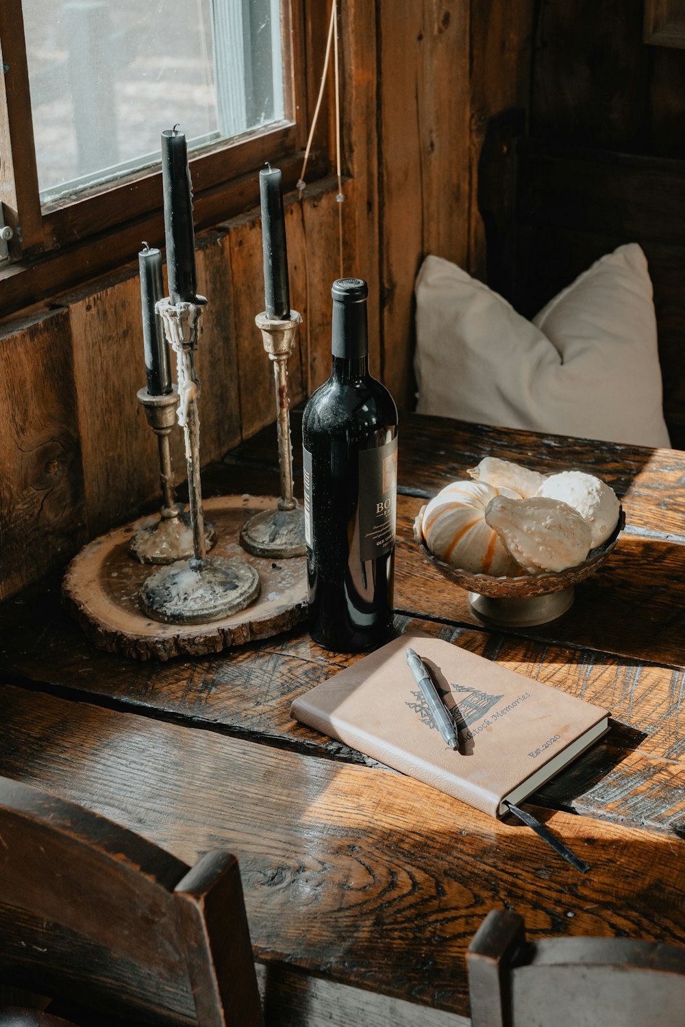 a wooden table topped with a bottle of wine