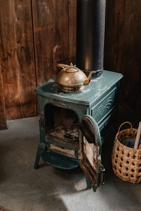 a green stove with a pot on top of it