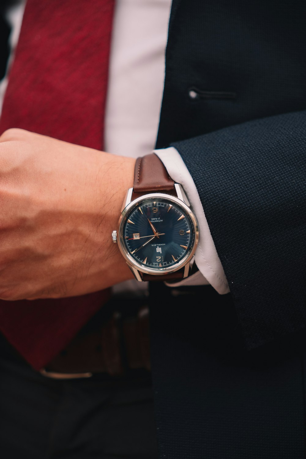 a man wearing a watch and a red tie