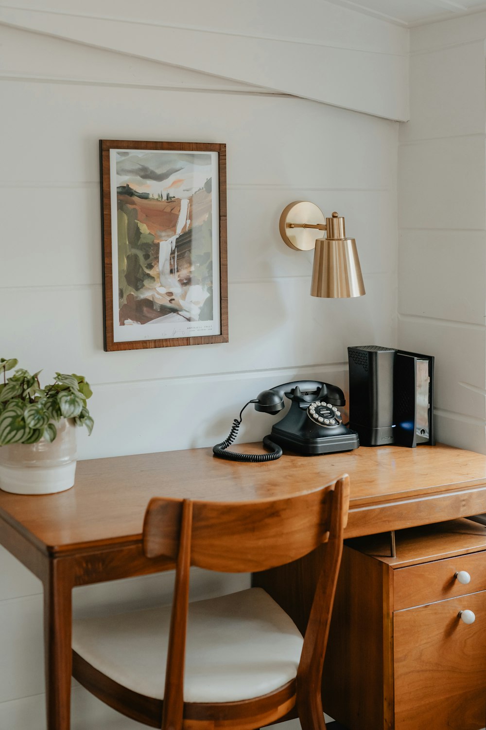 a wooden desk with a phone on top of it