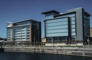 A panoramic view of a completed office complex with glass facades reflecting the Norwegian fjord nearby.