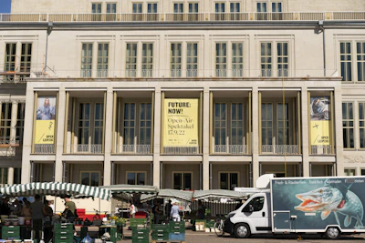 A rooftop banner overlooking a bustling market area, catching the eyes of pedestrians below.