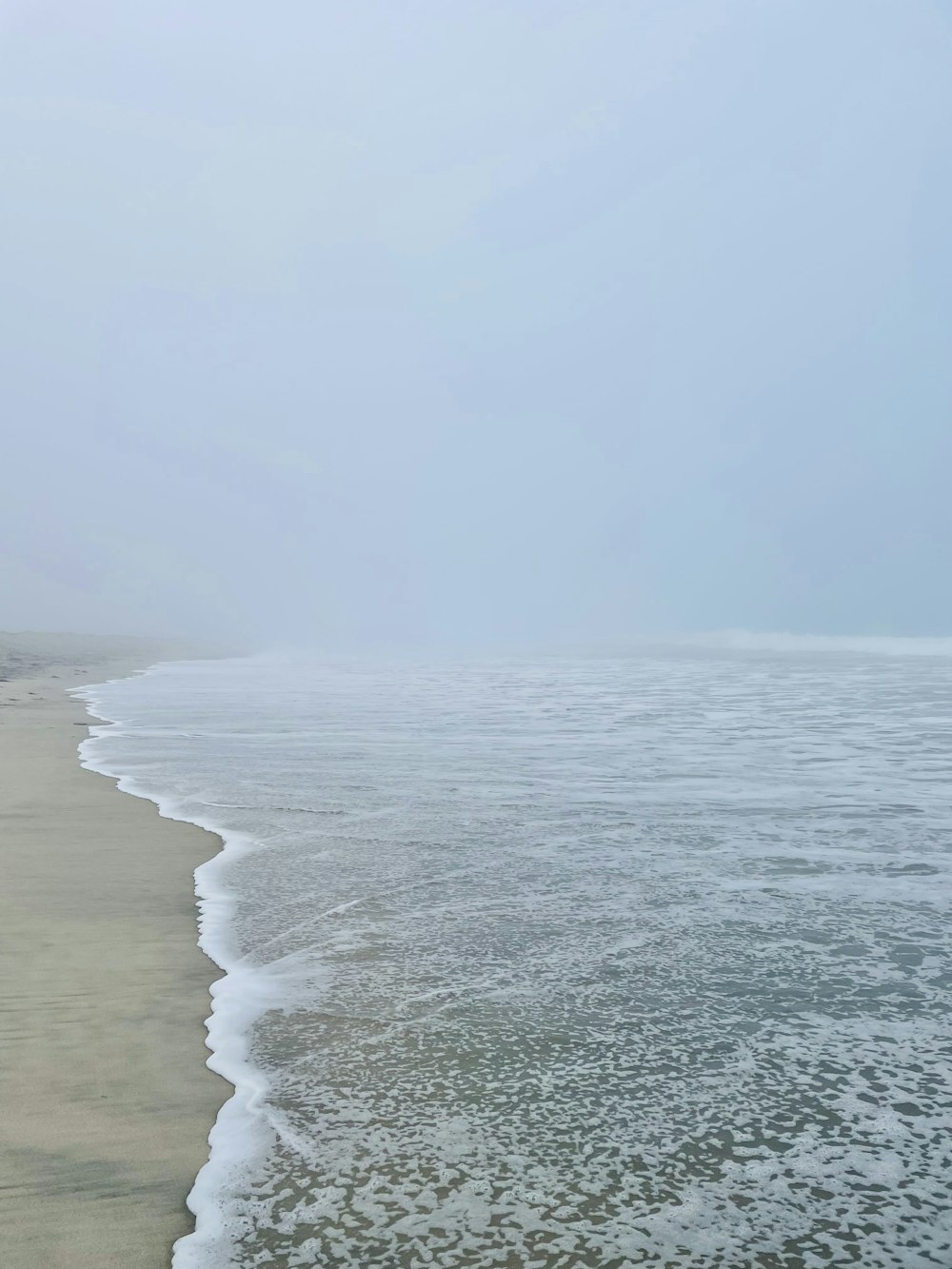 a sandy beach with waves coming in to shore