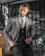 A confident male model wearing a fitted blazer in an urban city street.