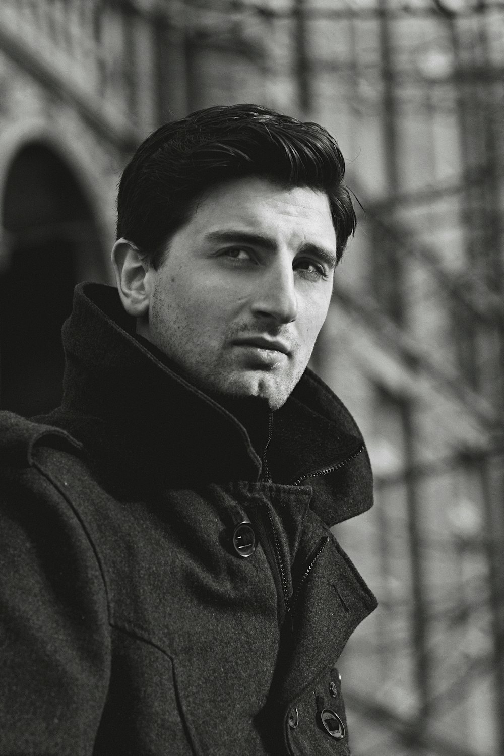 Una foto en blanco y negro de un hombre con abrigo