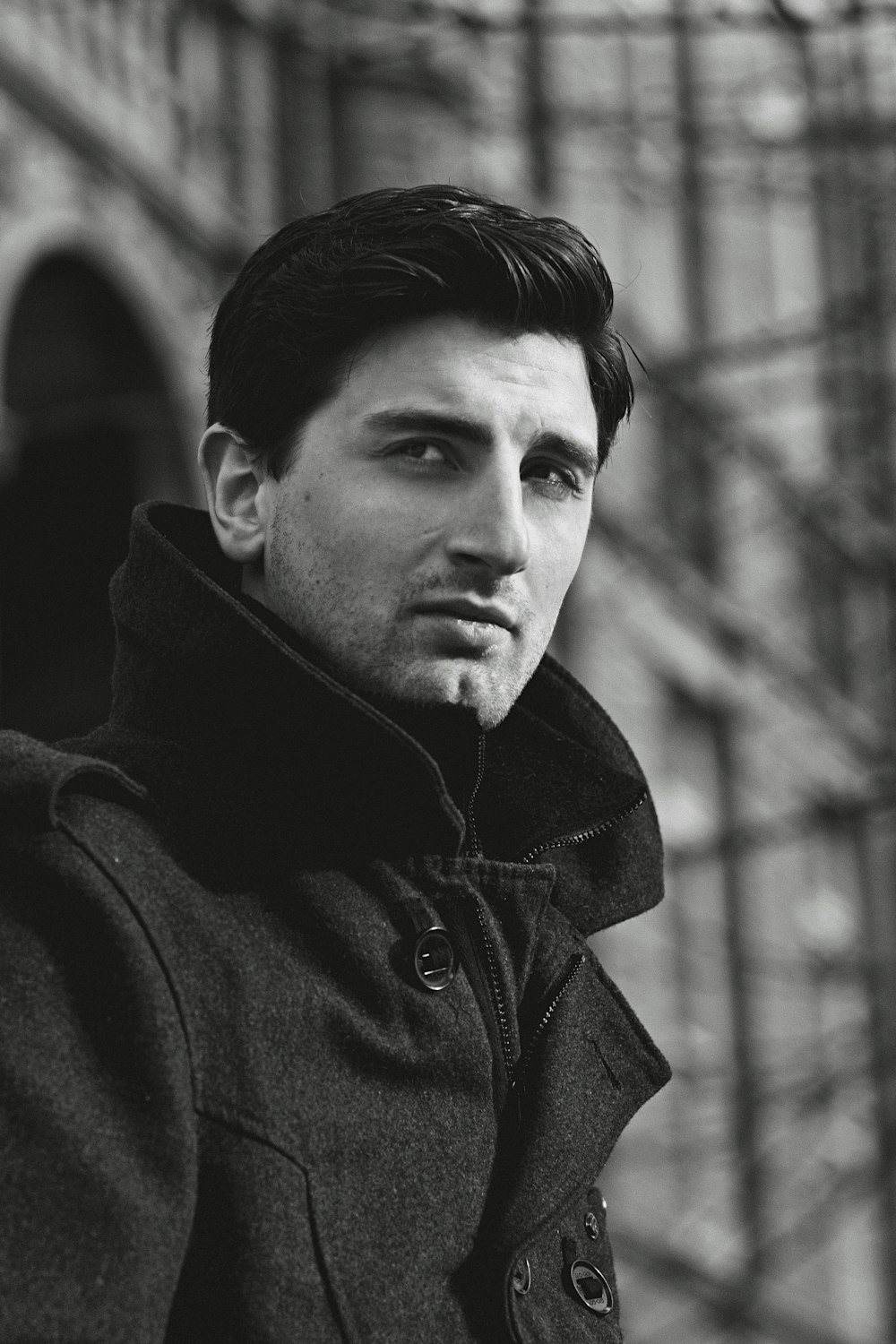 a black and white photo of a man in a coat