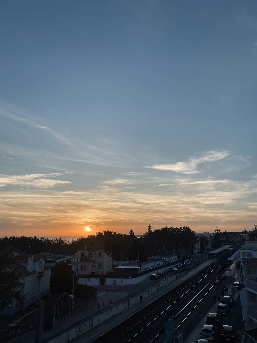 the sun is setting over a city street