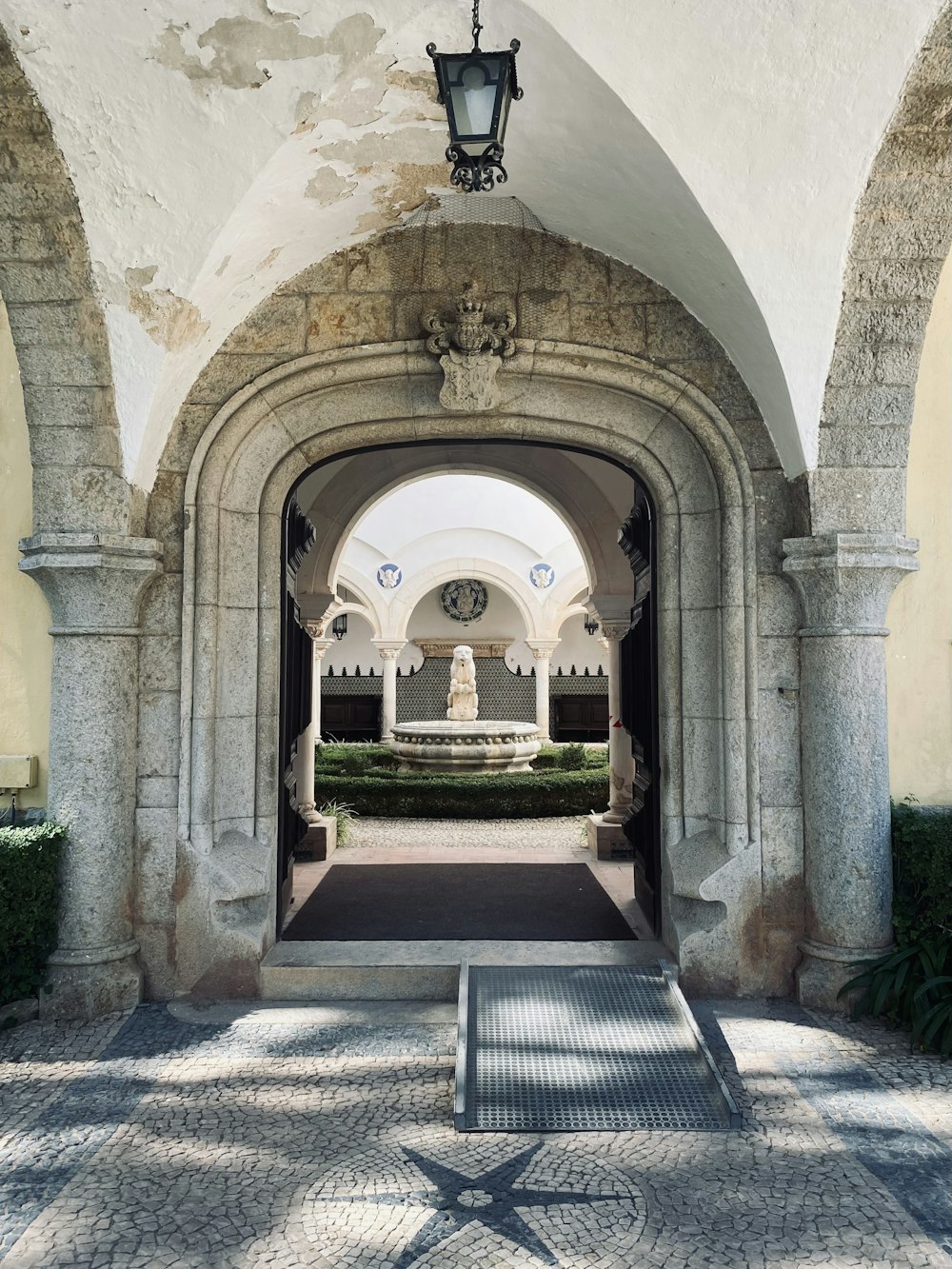 an archway leading into a courtyard with a fountain