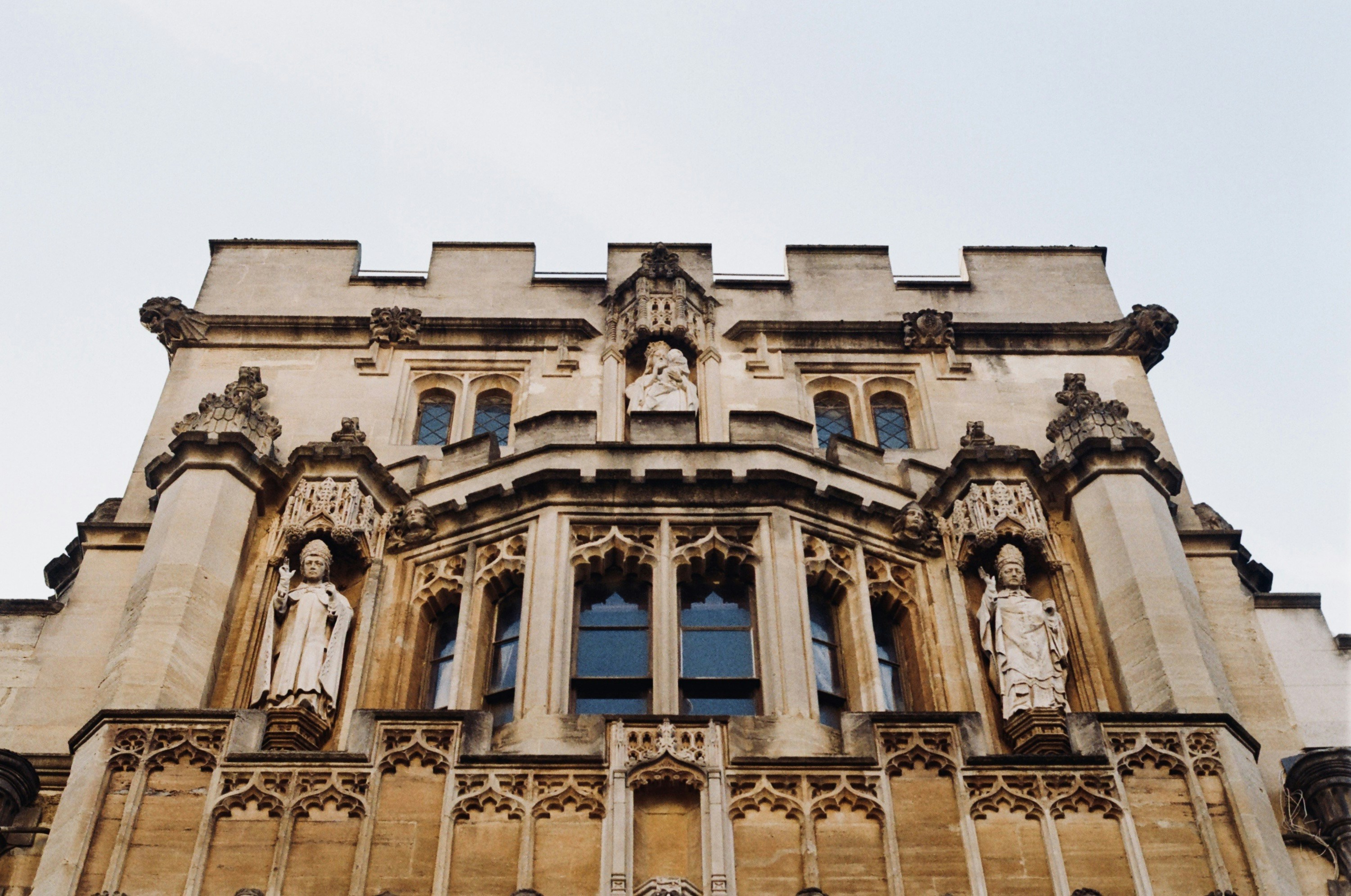 A tall building with statues on the front of it photo – Free People ...