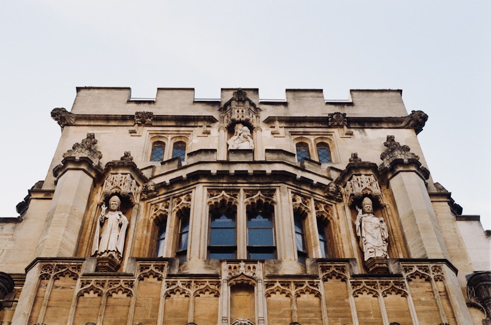 a tall building with statues on the front of it