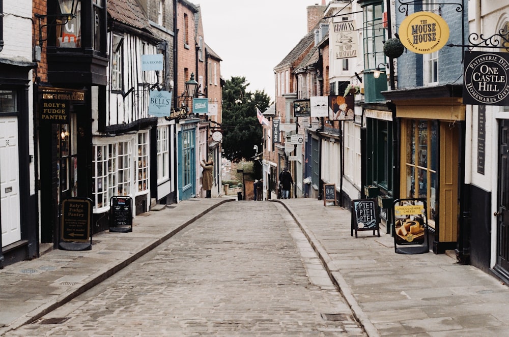 a narrow city street lined with buildings and shops