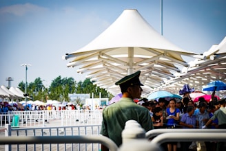 Large temporary canopy covering an outdoor event with people enjoying underneath.