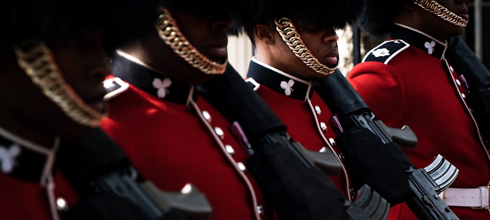 a group of men in red uniforms holding guns