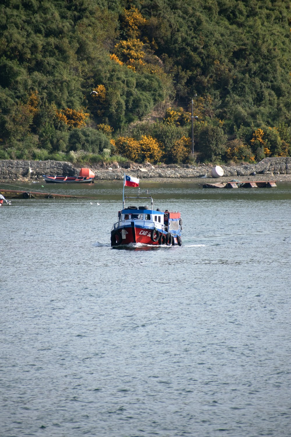 a red, white and blue boat in a body of water