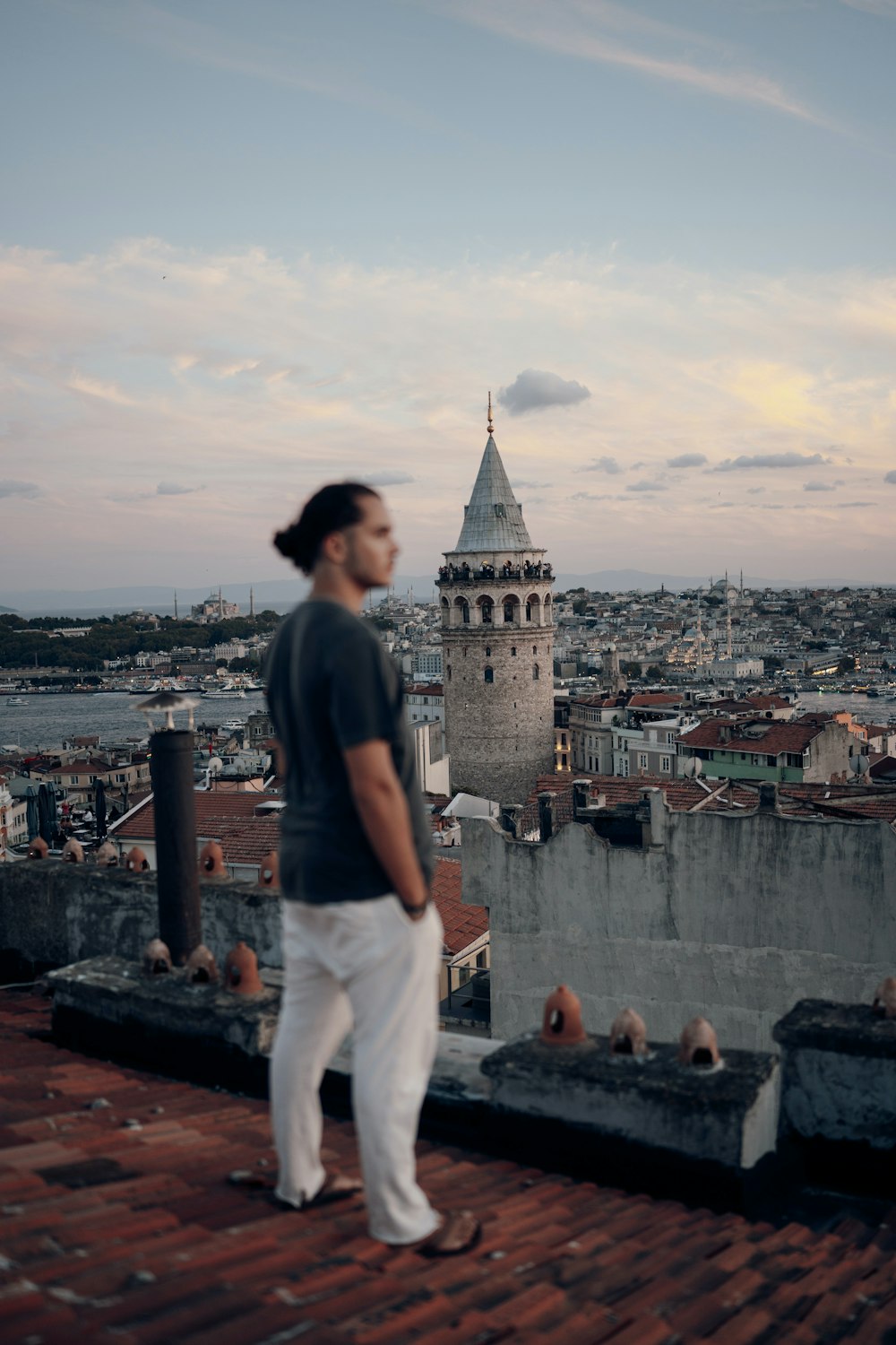 a man standing on top of a roof next to a tall building