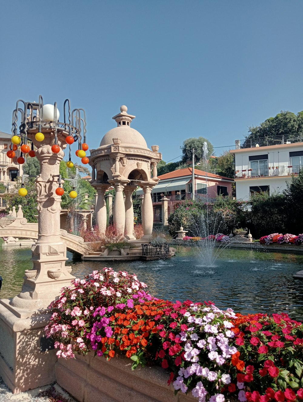 una fontana circondata da fiori in un parco