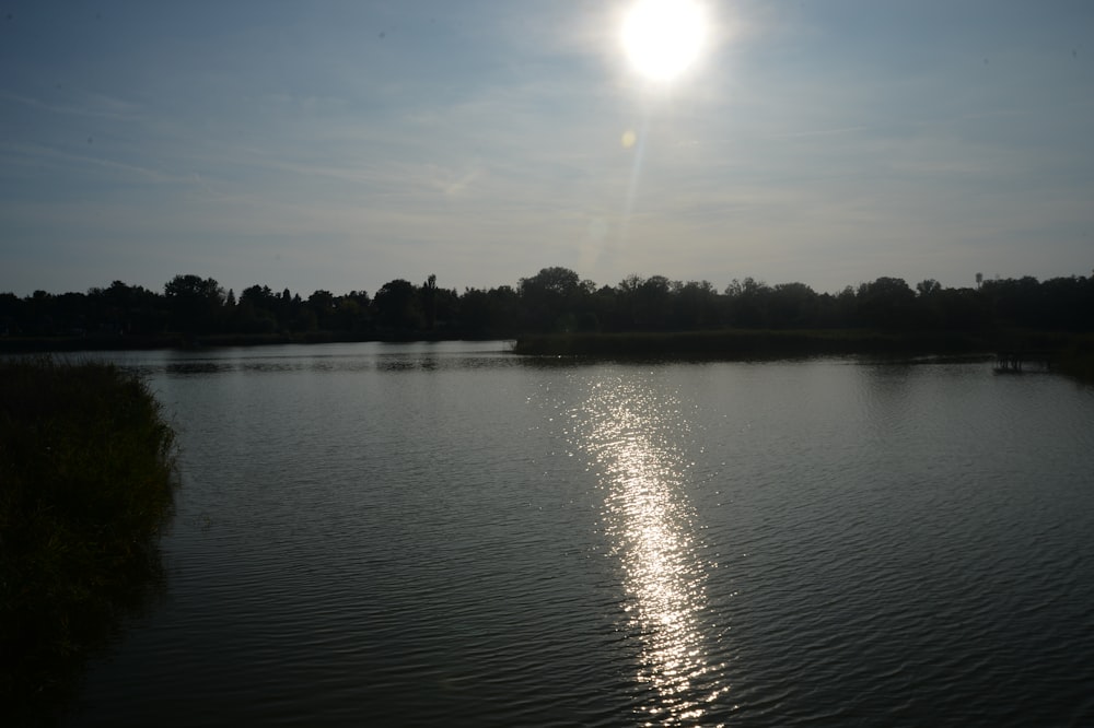 the sun shines brightly over the water of a lake
