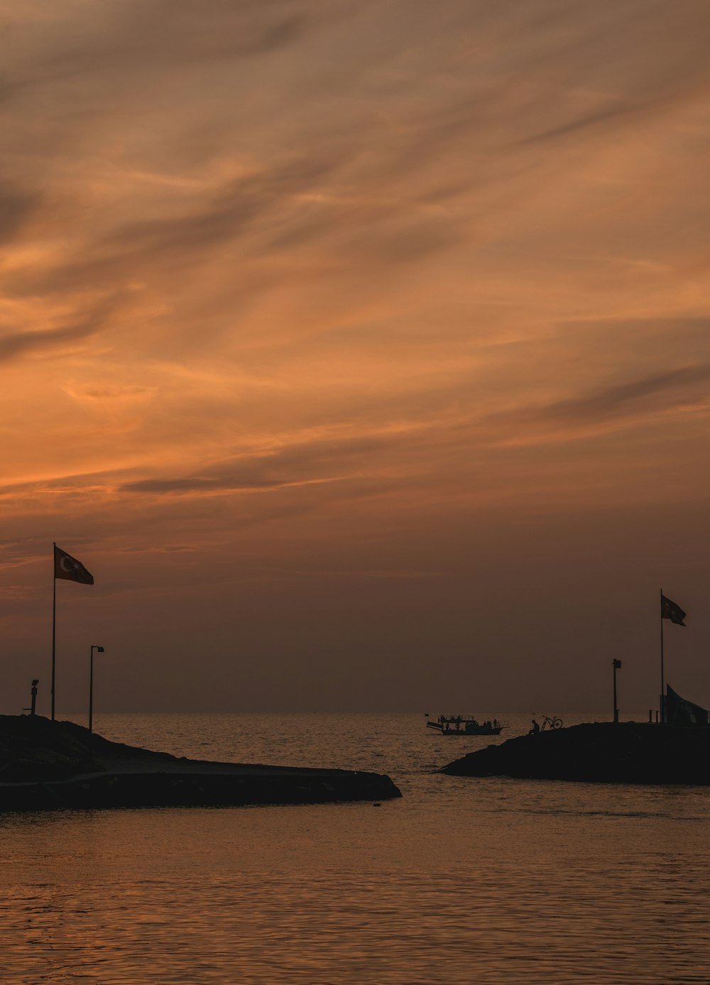 a sunset over a body of water with a boat in the distance