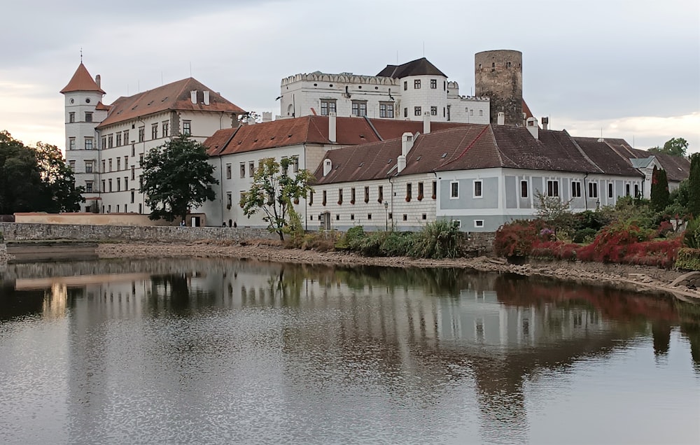 a large white building next to a body of water