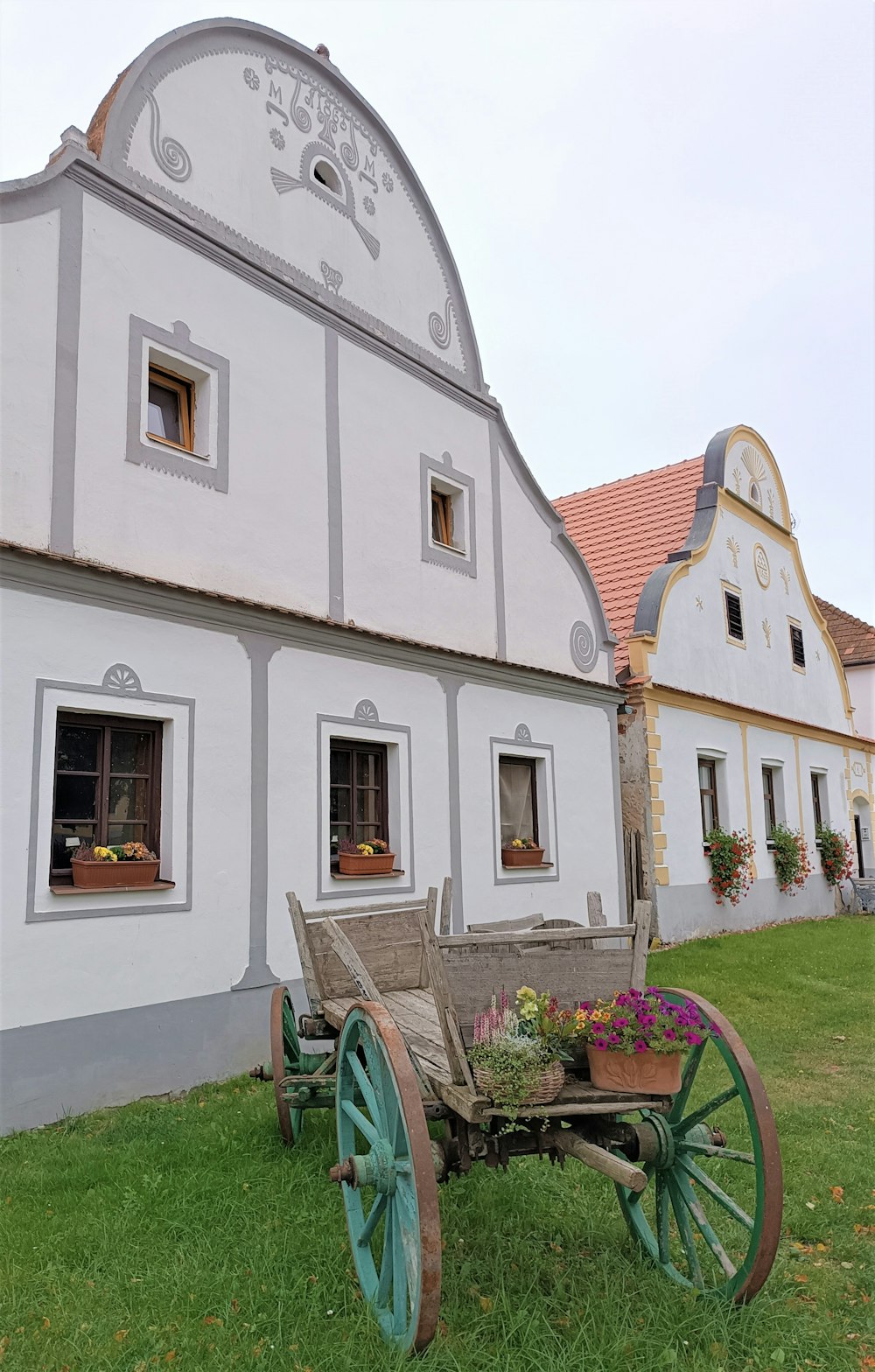 an old wooden wagon sitting in front of a white building