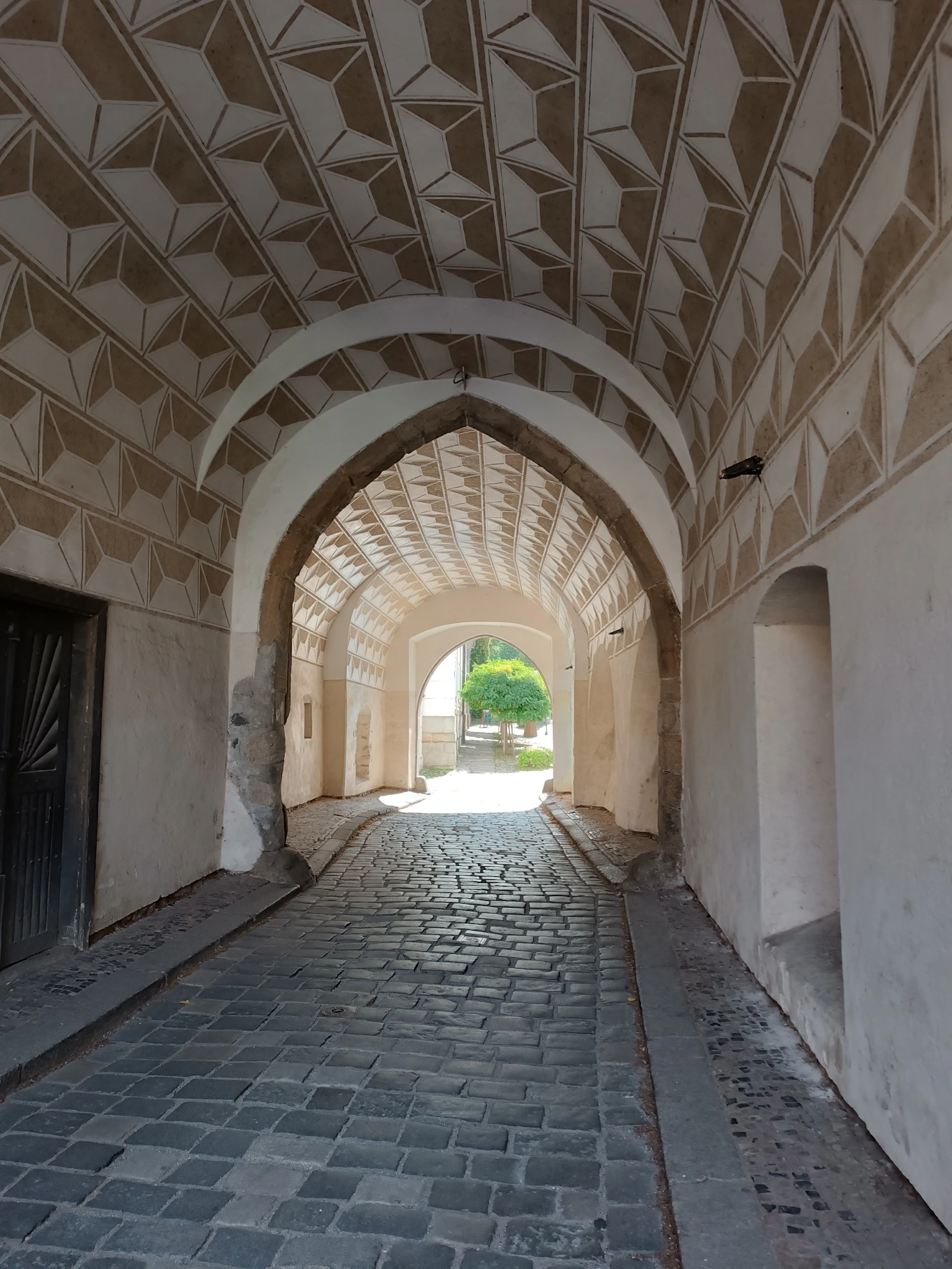 Decorated arch opens onto a courtyard in Třeboň