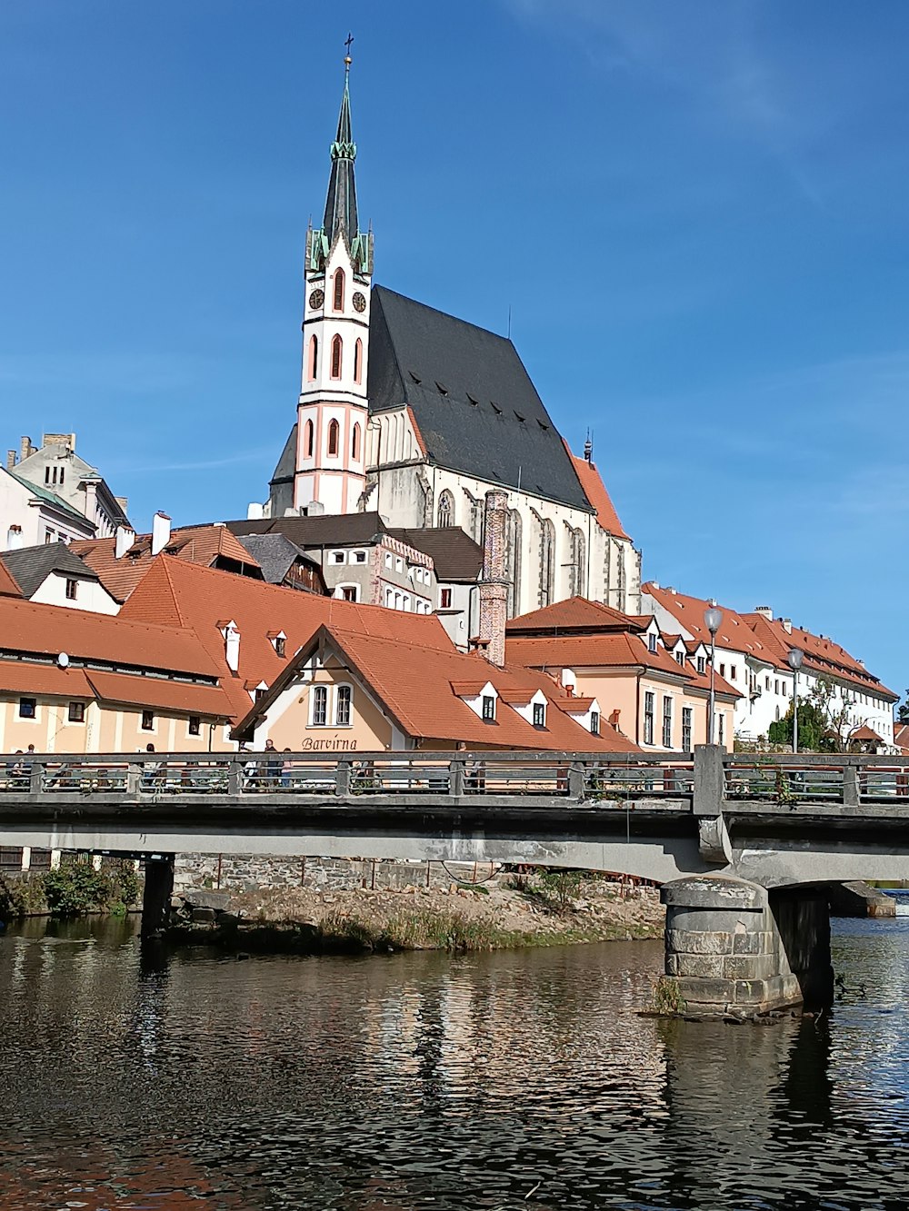 a bridge over a river with a church in the background