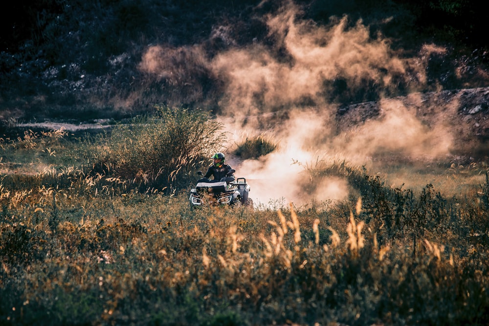 a person on a motorcycle driving through a field