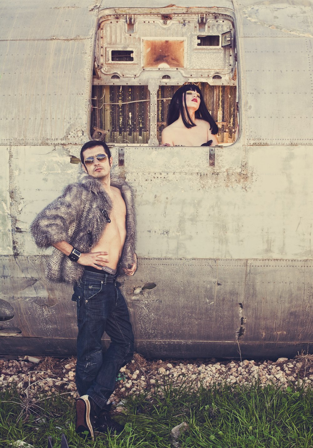 a man and a woman standing in front of an old airplane