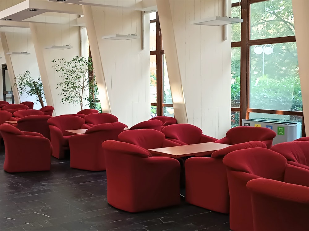 Una habitación llena de muchas sillas y mesas rojas