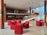 a lobby with red chairs and a spiral staircase