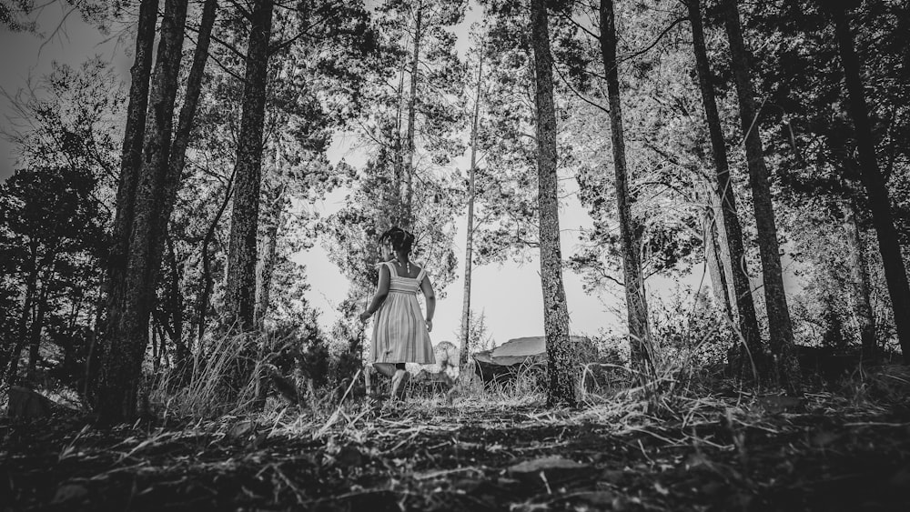 a woman standing in the middle of a forest