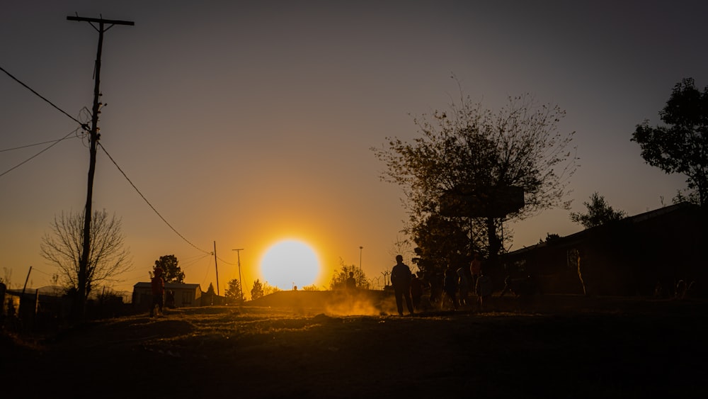 the sun is setting over a small village