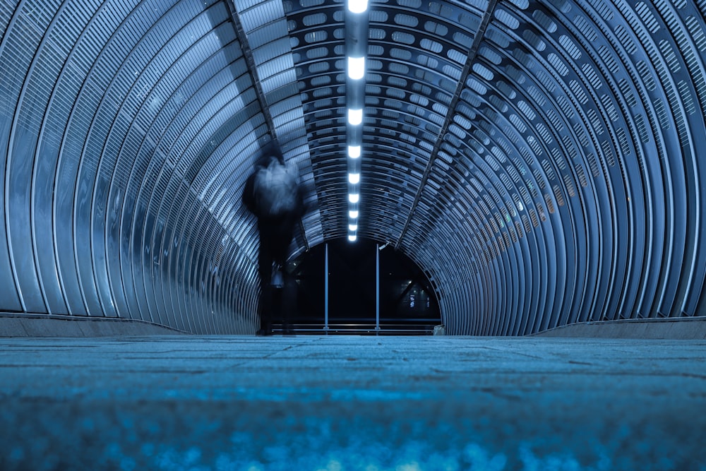 a tunnel with a person walking through it