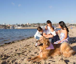 Family enjoying a sunny day at a Dubai beach with the city skyline in the background.
