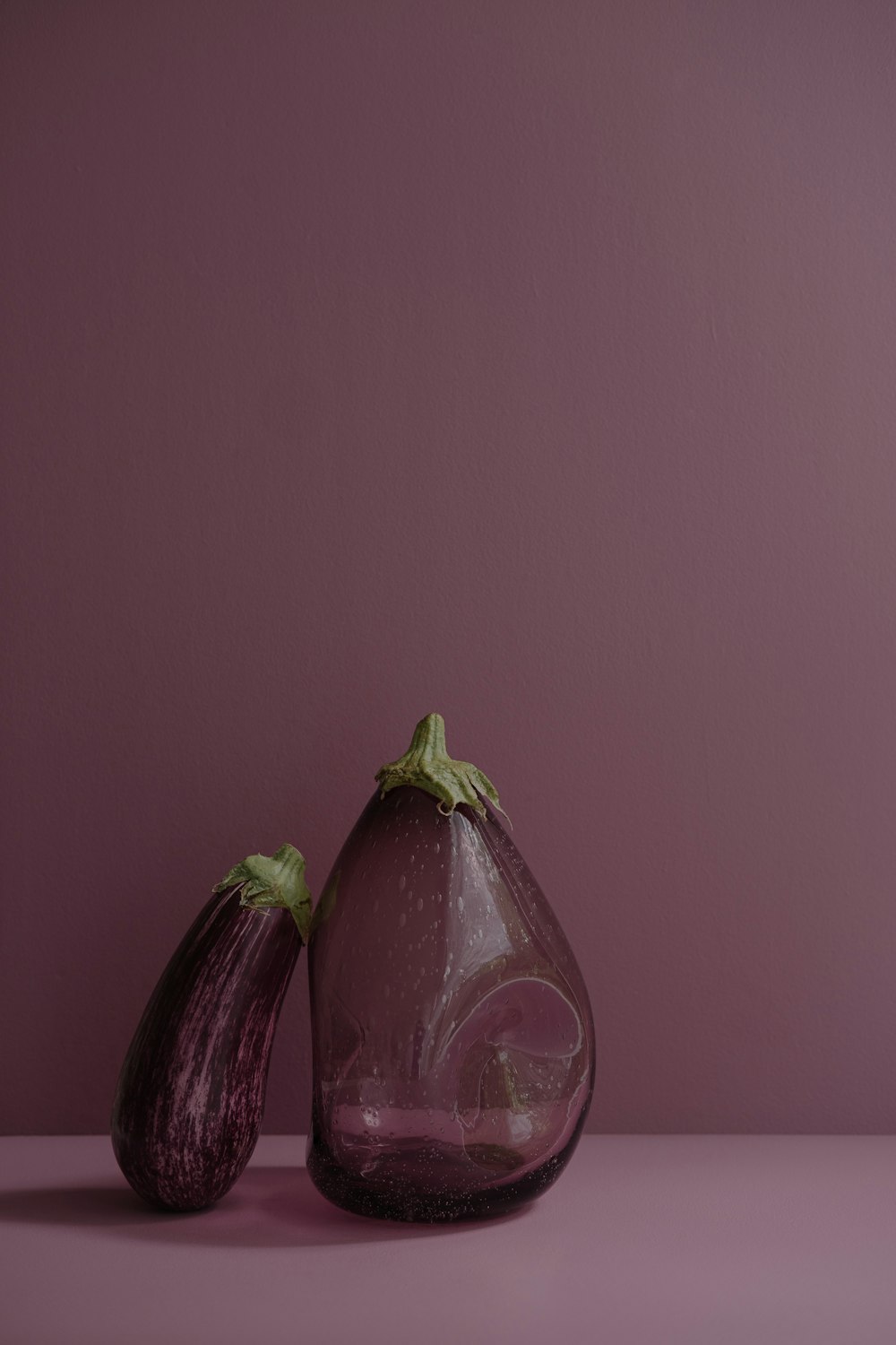 a purple vase with two eggplant halves in it