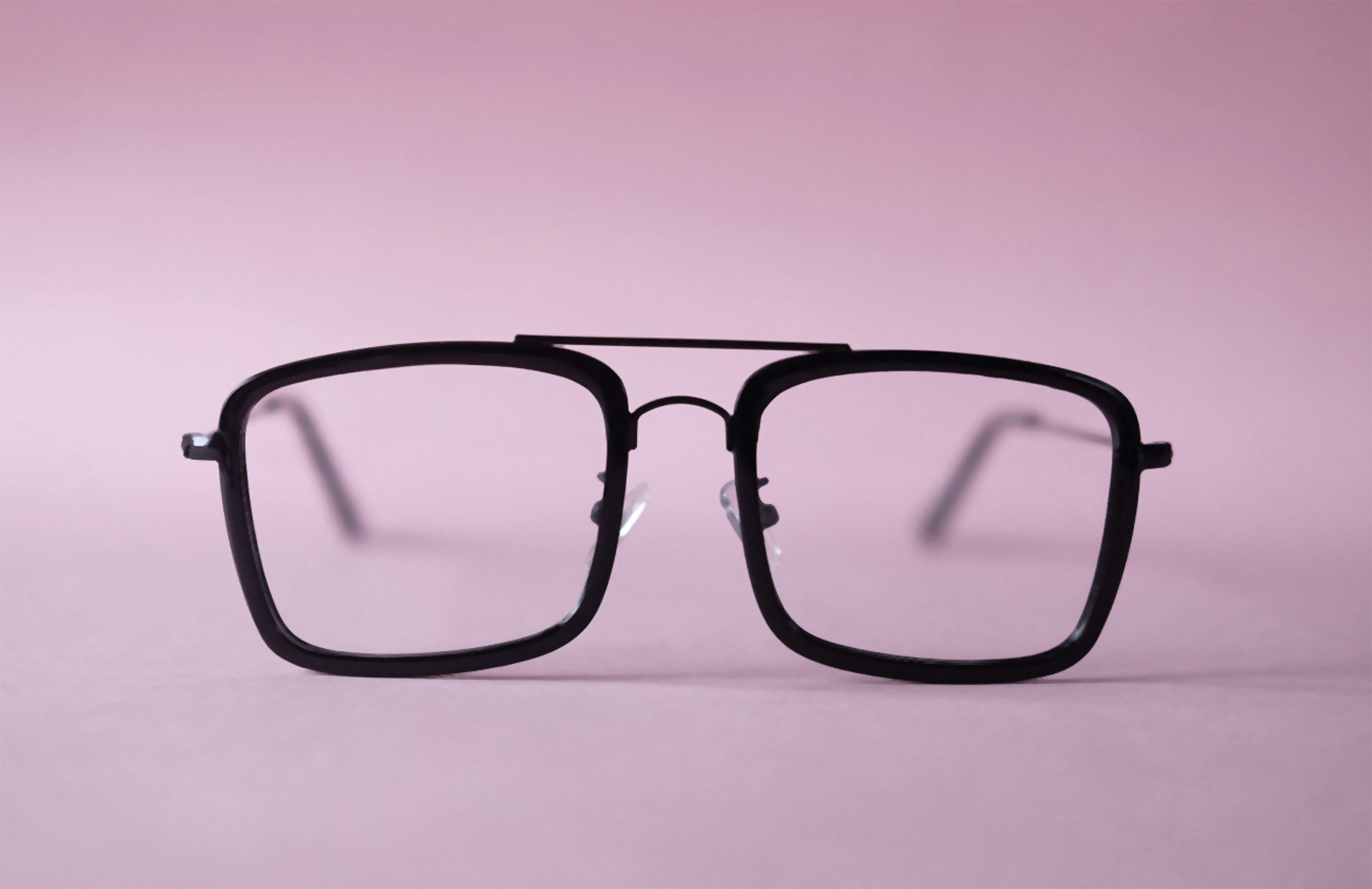 a pair of glasses on a pink background