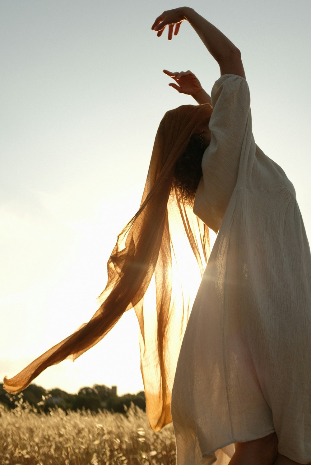 a woman in a white dress in a wheat field