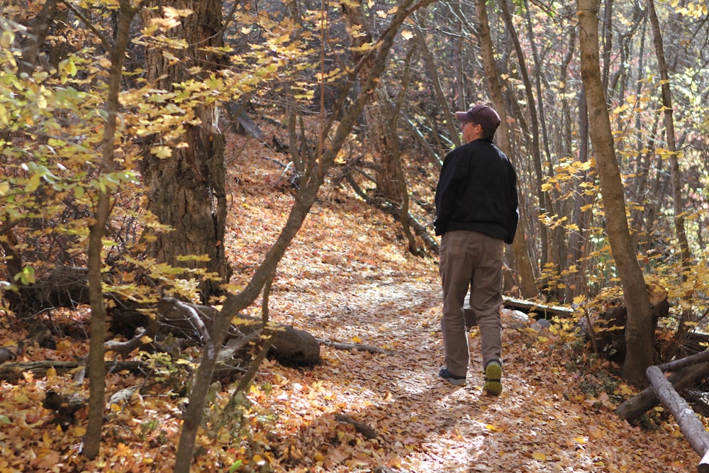 Un hombre parado en un sendero en el bosque