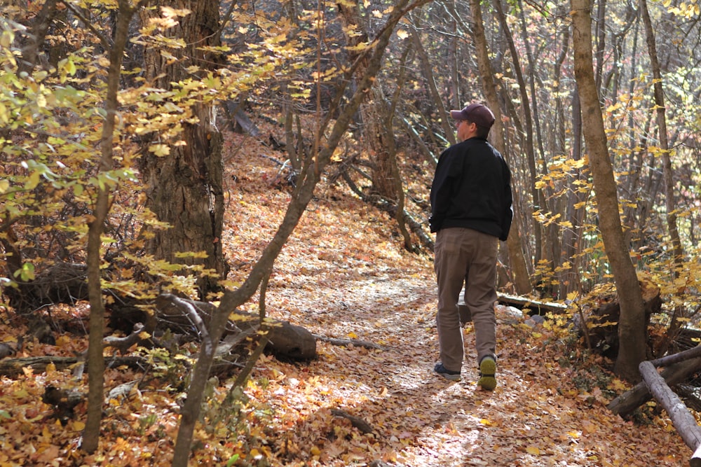 a man standing on a trail in the woods