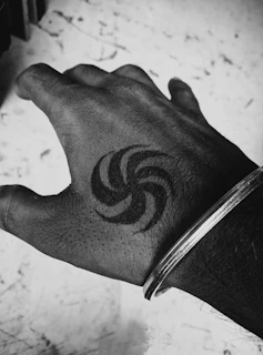 Black and white photo of a hand tattoo featuring intricate dotwork and fine details.