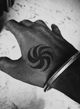 Black and white photo of a hand tattoo featuring intricate dotwork and fine details.