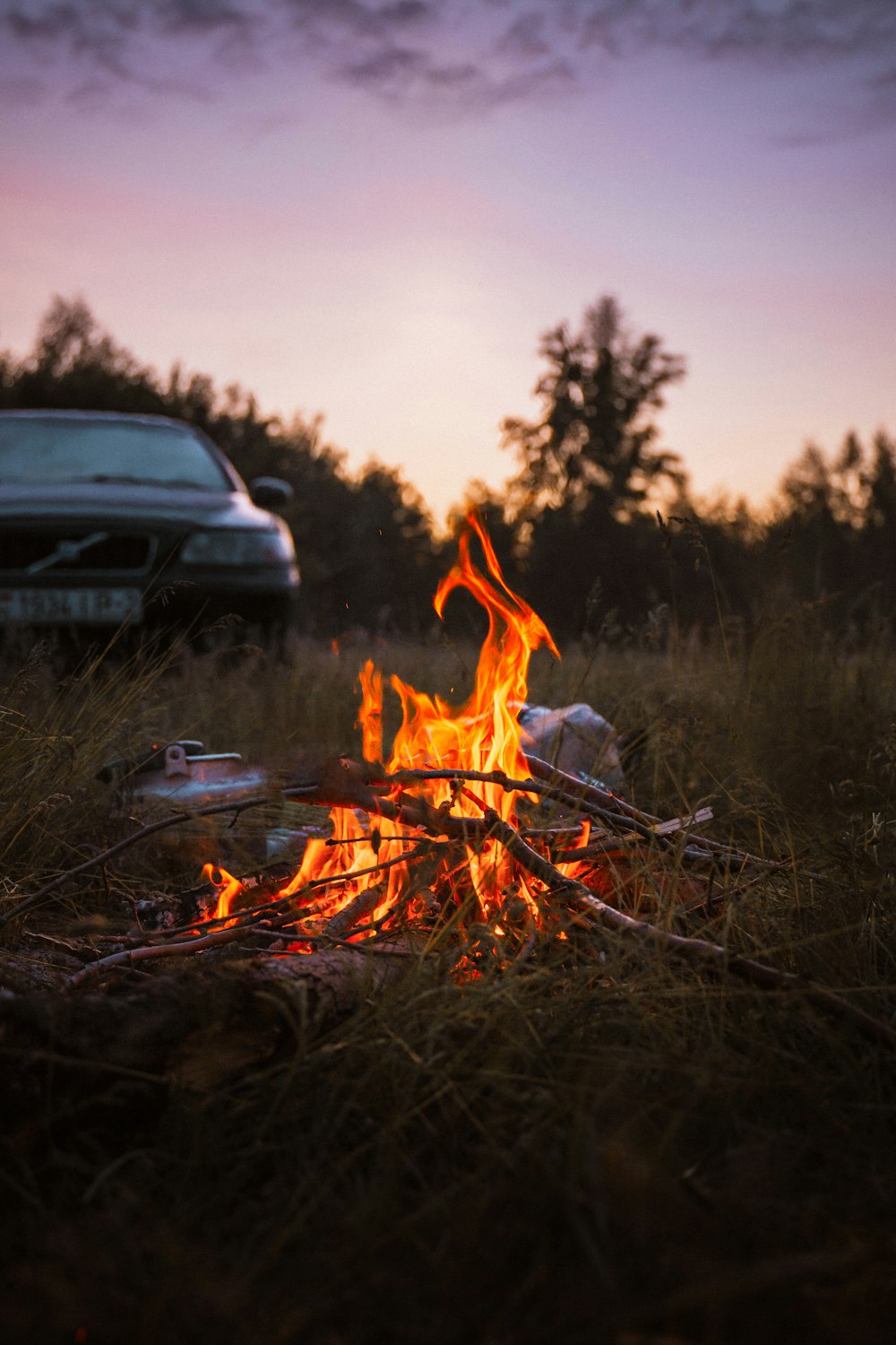 a campfire with a car in the background