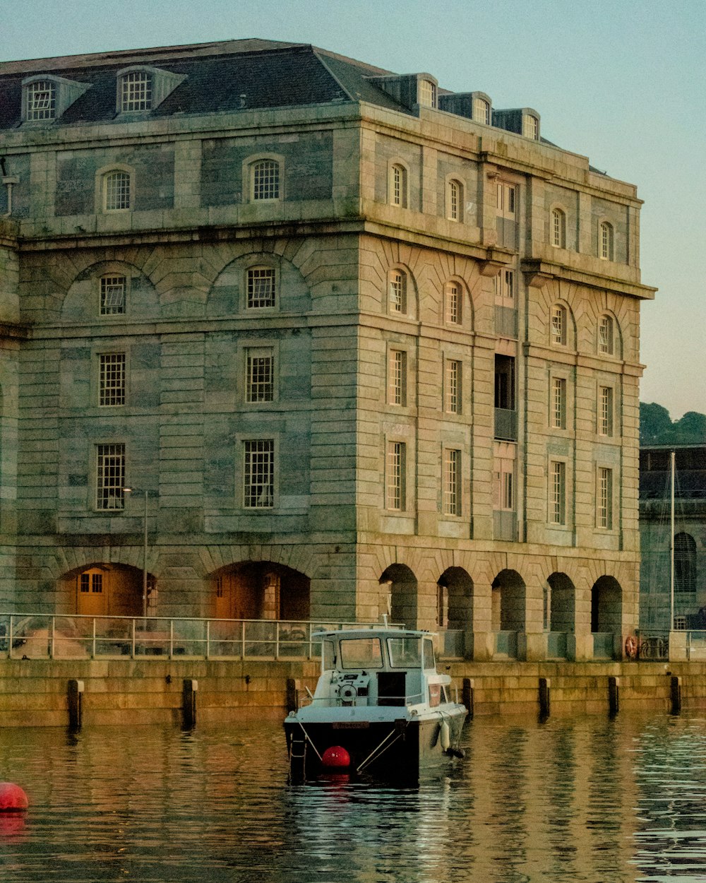 a boat in the water in front of a large building