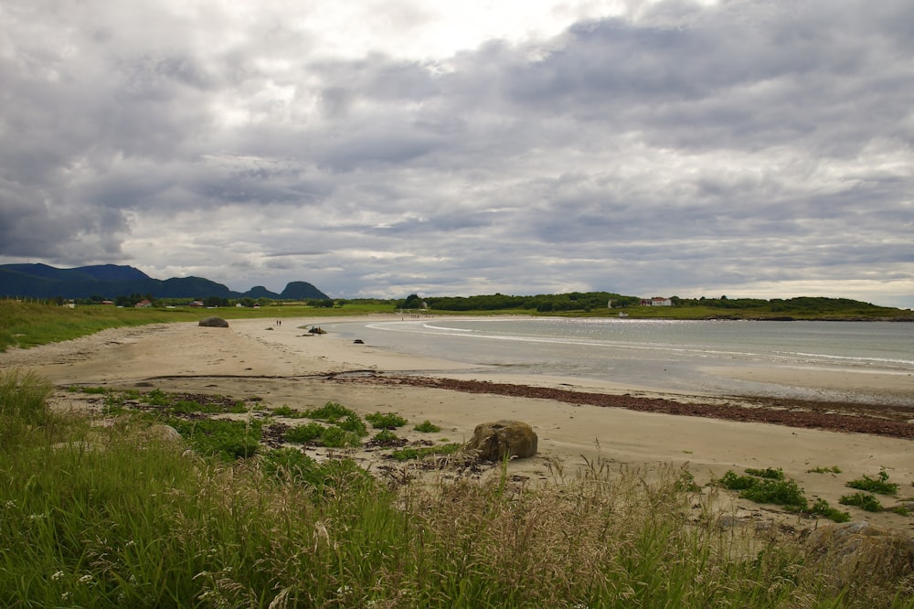 a sandy beach with a body of water in the distance