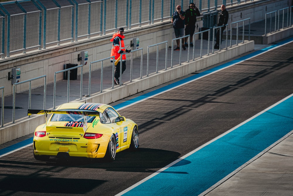 a yellow car driving down a race track