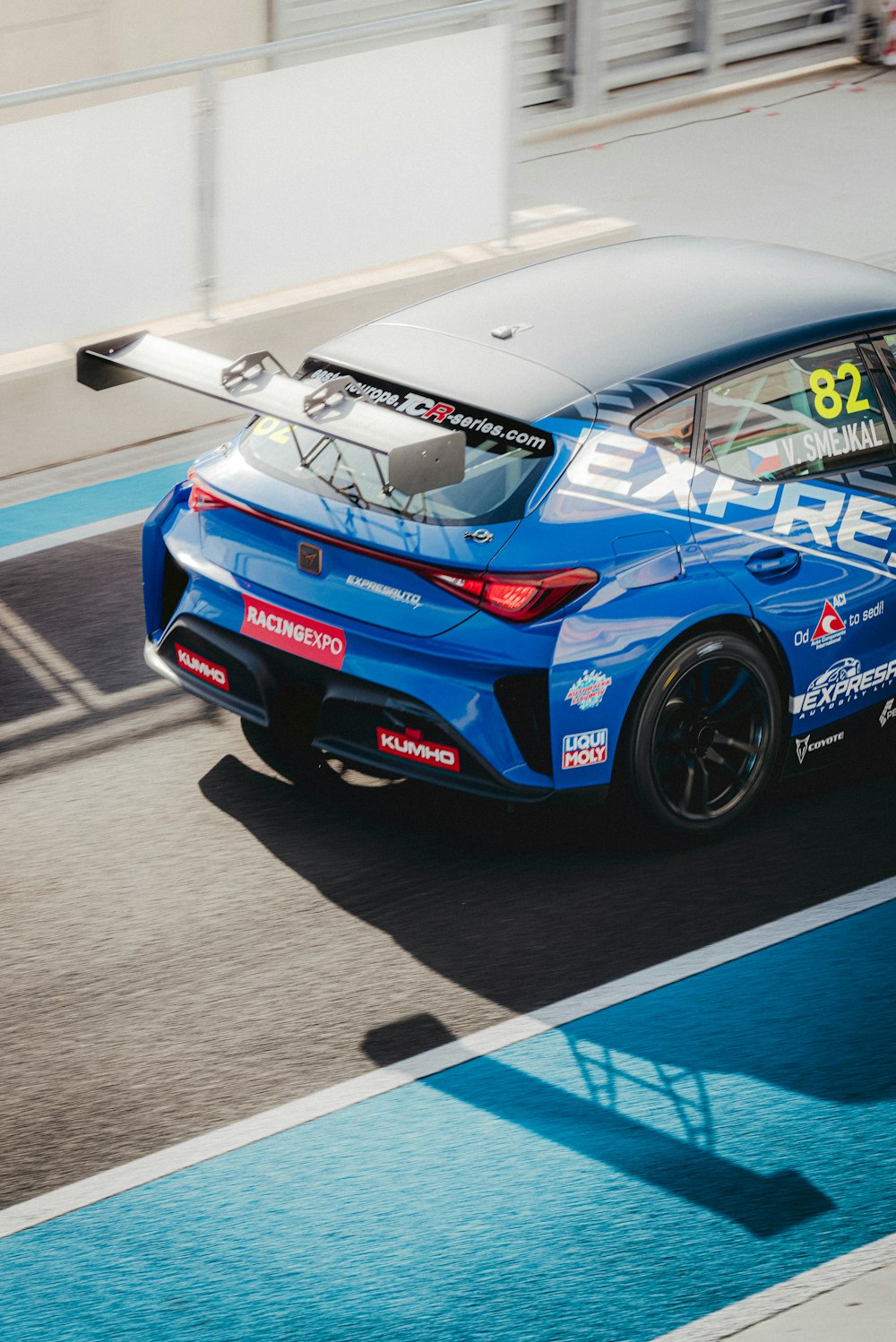 Une voiture de sport bleue roulant sur une piste de course